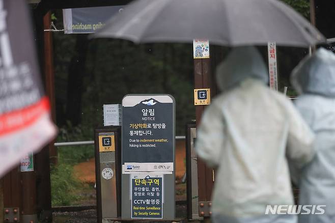 [제주=뉴시스] 우장호 기자 = 제주도 산지에 호우주의보가 내려진 27일 오전 제주 한라산 어리목 탐방로 입구에 입산통제 알림판이 서 있다. 한라산국립공원은 정체전선 활성화로 기상이 악화하자 어리목과 영실, 성판악 등 7개 탐방로의 입산을 전면 통제했다. 2023.06.27. woo1223@newsis.com