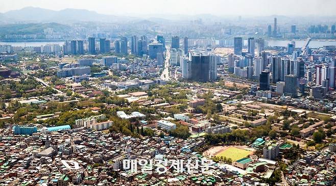 서울 남산에서 내려다본 용산구 일대 전경. 삼각지역 사거리를 중심으로 남쪽(사진 상단) 한강변엔 고층 아파트와 오피스 빌딩들이 들어서 있는 반면 북쪽(하단)엔 저층 주택과 상가 건물이 몰려 있어 대비를 이룬다.  [이승환 기자]