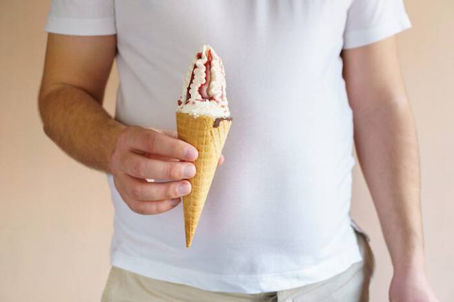 sugar addiction, healthy lifestyle, weight loss, dietary, balanced nutrition. cropped portrait of overweight man eating ice-cream in waffle cone