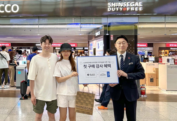 곽종우 인천공항 신세계면세점장(오른쪽)과 첫 구매고객이 기념사진을 찍고 있다. [사진제공=신세계면세점]