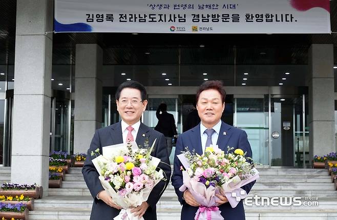 '전남·경남 상생발전 협약식'이 18일 오후 경남도청에서 열린 가운데 김영록 전라남도지사(왼쪽)가 경남도청 직원들의 환영 꽃다발을 증정받은 뒤 박완수 경남도지사와 기념촬영을 하고 있다.