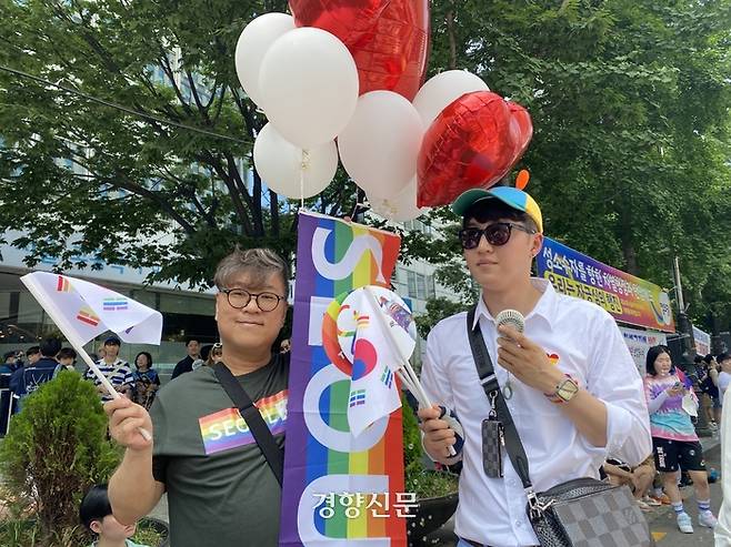 1일 서울퀴어문화축제에 참가한 봉준영씨(왼쪽) 커플이 무지개색 태극기를 흔들고 있다. 윤기은 기자