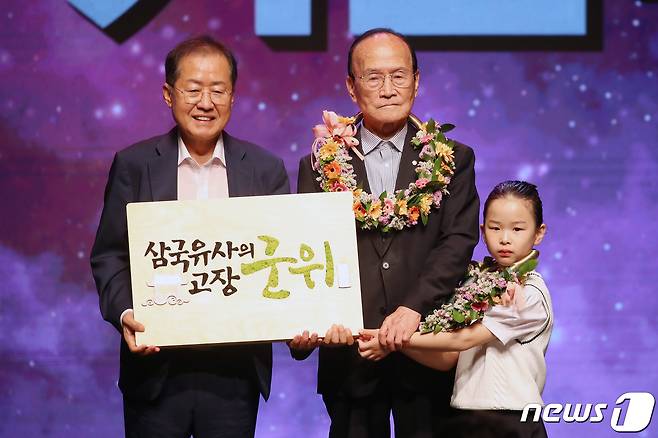 3일 오전 대구문화예술회관에서 열린 '군위군 대구광역시 편입 기념식'에서 홍준표 대구시장이 군민 대표에게 군위 브랜드 슬로건 액자를 전달받고 답례로 꽃목걸이를 걸어준 뒤 기념촬영을 하고 있다. 2023.7.3/뉴스1 ⓒ News1 공정식 기자