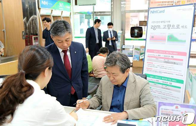 류광석 유성농협 조합장(오른쪽 첫번째)은  정낙선 농협 대전본부 총괄본부장(가운데)이 지켜보는 가운데 ‘zgm. 고향으로 카드’릴레이 가입 캠페인에 참여하고 있다.(농협 대전본부 제공)  /뉴스1