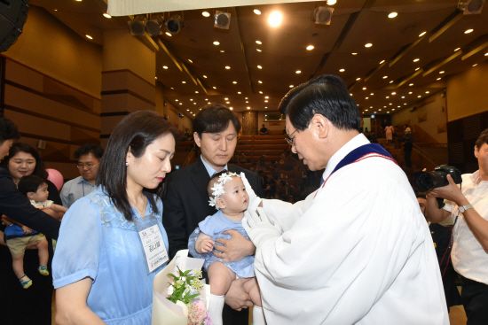 이영훈 여의도순복음교회 담임목사가 지난달 25일 열린 헌아식 중 아기에게 축복하고 있다. 여의도순복음교회 제공