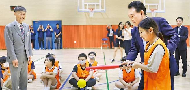 윤석열 대통령이 3일 방과 후 돌봄·교육 프로그램인 ‘늘봄학교’ 참관을 위해 경기 수원초등학교를 방문했다. 전직 프로야구 선수들이 강사로 초빙된 가운데 윤 대통령이 야구 배트를 든 한 여학생의 자세를 교정해주고 있다. /김범준 기자