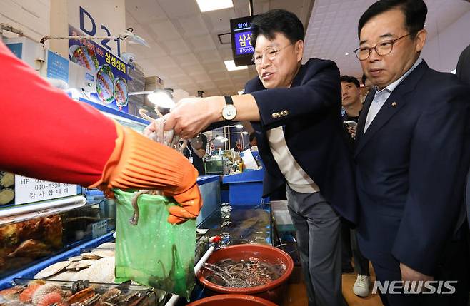 [서울=뉴시스] 황준선 기자 = 장제원 국회 과학기술정보방송통신위원회(과방위) 위원장이 3일 오전 서울 동작구 노량진수산시장을 찾아 낙지를 구입하고 있다. 2023.07.03. hwang@newsis.com