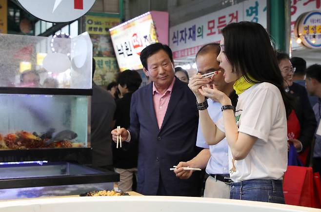 윤석열 대통령 부인 김건희 여사(맨 앞)가 3일 오후 강원도 강릉시 중앙·성남시장을 방문해 횟집에서 오징어회를 시식하고 있다. 강릉=연합뉴스