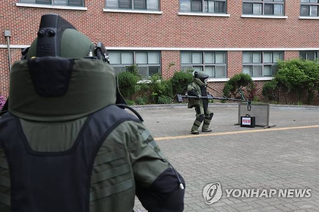 학교에 출동한 폭발물 처리반 (의정부=연합뉴스) 임병식 기자 = 26일 경기도 의정부시 녹양중학교에서 실시된 경기도 2023년 대테러 및 예측불가 사회재난 합동훈련에서 경기북부경찰청 경찰특공대 폭발물처리반이 폭발물로 추정되는 가방을 제거하기 위해 안전한 곳으로 옮기고 있다. 2023.4.26 andphotodo@yna.co.kr