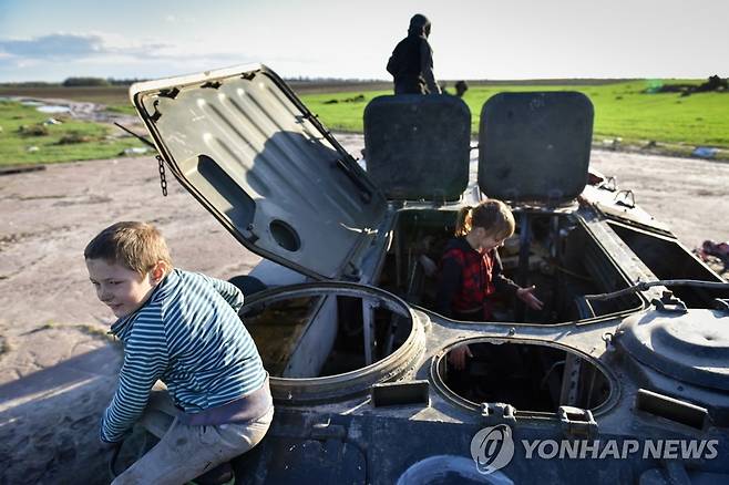 우크라 어린이 놀이터 된 러군 장갑차 (체르니히우 EPA=연합뉴스) 우크라이나 북부 체르니히우에서 27일(현지시간) 어린이들이 파괴된 러시아군 장갑차를 놀이터 삼아 놀고 있다. 체르니히우는 러시아군이 침공 초기에 집중 공격을 퍼붓다가 병력을 재배치하면서 철수한 지역이다. 2022.4.28 sungok@yna.co.kr