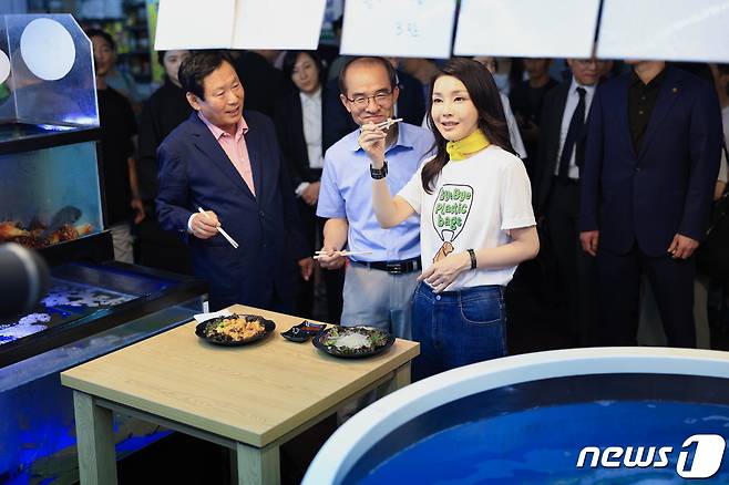 김건희 여사가 3일 오후 강원도 강릉시 중앙·성남시장을 찾아 오징어회를 시식하고 있다. (대통령실 제공) 2023.7.3/뉴스1 ⓒ News1 안은나 기자