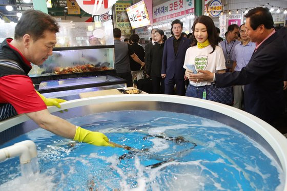 김건희 여사가 3일 오후 강원도 강릉시 중앙·성남시장을 방문해 횟집에서 상인이 오징어를 뜰채로 건지는 모습을 바라보고 있다. 대통령실통신사진기자단