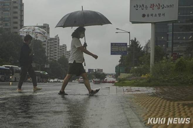 수도권 전역에 호우주의보가 발효된 지난달 29일 오후 서울 송파구 잠실역 인근거리에서 우산을 쓴 시민들이 발걸음을 재촉하고 있다.   사진=임형택 기자