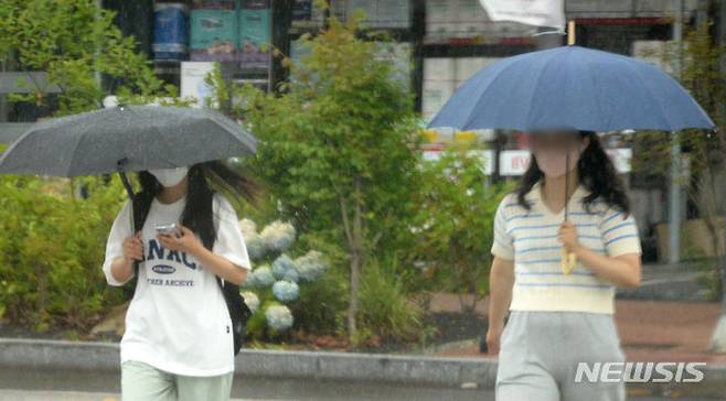 [전주=뉴시스] 김얼 기자 = 전국적으로 장맛비가 내리기 시작한 26일 전북 전주시 백제대로에서 시민들이 우산으로 비를 피하며 길을 지나고 있다. 2023.06.26. pmkeul@nwsis.com