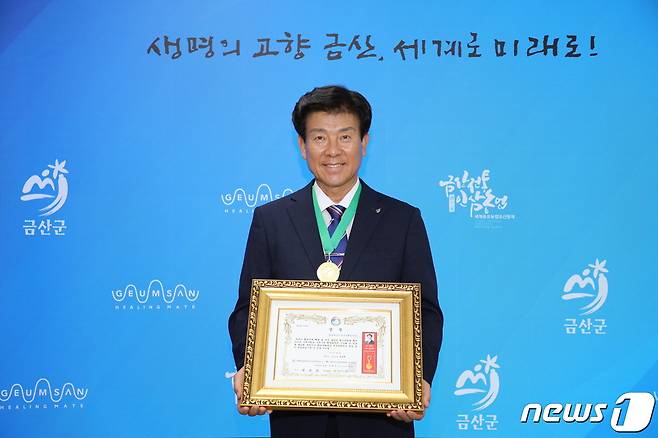 박범인 금산군수가 군수실에서 제21회 대한민국 환경문화대상 지방자치행정부분 환경대상을 들고 기념사진을 찍고 있다.(금산군 제공) /뉴스1