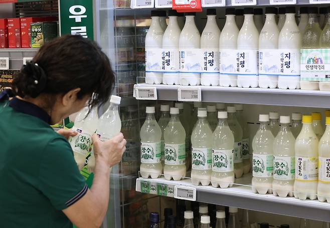 4일 서울의 한 대형마트에서 한 시민이 막걸리를 고르며 설탕 대체 인공감미료 '아스파탐'이 들어있는지 확인하고 있다. 세계보건기구(WHO) 산하 국제암연구소(IARC)가 아스파탐을 '발암 가능 물질'(2B군)로 지정한다는 방침인 것으로 알려졌다. 서울장수의 경우 '달빛유자 막걸리'를 제외한 모든 제품에 아스파탐이 들어있으며 지평주조 '지평생막걸리', 국순당 '생막걸리' 등에 아스파탐이 들어있다./뉴스1