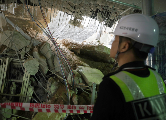 An official from the Korea Authority of Land & Infrastructure Safety inspects the ruins of a collapsed roof at an underground parking lot in Incheon. [NEWS1]