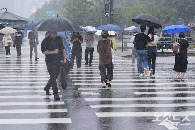 본격적인 장마가 시작된 26일 오후 서울 광화문 네거리에 우산을 쓴 시민들이 발걸음을 재촉하고 있다. 류영주 기자