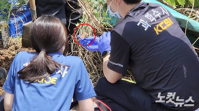 5일 오전 부산 기장군 유기 영아 수색현장에서 경찰이 발견한 뼛조각(빨간 원)을 살펴보고 있다. 박진홍 기자