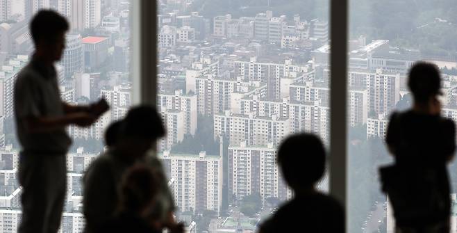 관광객들이 서울 송파구 롯데월드타워 전망대에서 아파트로 빼곡한 서울 시내를 바라보고 있다. / 뉴스1