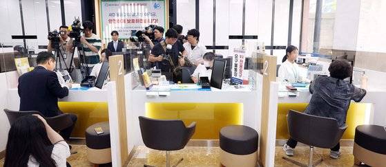 새마을금고 현장방문에 나선 한창섭(왼쪽) 행정안전부 차관이 6일 오전 서울 종로구 교남동새마을금고 경희궁지점에서 통장을 개설하는 사이 한 고객이 예금 해지 상담을 하고 있다. 뉴시스