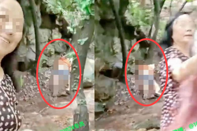 쓰러진 여성을 배경으로 ‘셀카’를 찍는 중국 여성에 비난이 일고 있다. [사진출처 = 웨이보]