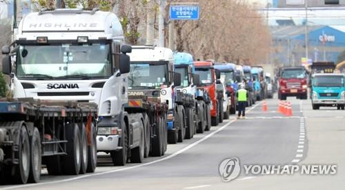 '멈춘 차, 달리는 차' (포항=연합뉴스) 김현태 기자 = 화물연대 파업이 이어진 지난해 12월 5일 경북 포항시의 한 도로에서 갓길에 줄지어 서 있는 화물차들 옆으로 운행 중인 유류 운반차, 화물차가 지나가고 있다. [연합뉴스 자료사진]