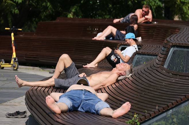7월 4일 러시아 모스크바 도심 자리야디 공원에서 사람들이 일광욕을 즐기고 있다./TASS 연합뉴스