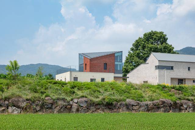 경기 양평 전원 마을에 균형 잡힌 모습으로 자리한 2층 주택. 삼각형 지붕의 양쪽으로는 각각 다락과 온실이 들어섰다. 신경섭 건축사진작가 제공