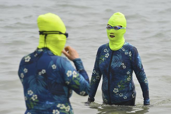 지난달 24일(현지시간) 중국 산둥성 칭다오에서 두 명의 여성이 물에 들어가 더위를 식히고 있다./AFPBBNews=뉴스1