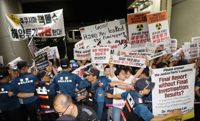 라파엘 그로시 국제원자력기구(IAEA) 사무총장의 입국이 예정된 7일 저녁 서울 강서구 김포공항 국제선에서 정의당과 민주노총을 비롯한 시민단체 회원들이 후쿠시마 원전 오염수 해양 방류를 규탄하며 손 피켓 시위를 하고 있다. (사진=뉴스1)