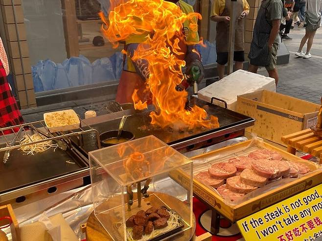 스테이크를 파는 A씨가 고기에 불향을 입히고 있는 모습입니다. 한 외국인 관광객은 이 불쇼를 보더니 휴대폰을 꺼내들고 동영상을 촬영했습니다. 김지호 인턴기자