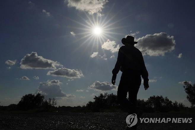 이상고온 현상으로 수량이 줄어든 리오그란데 강 주변을 걷는 현지 주민 [AP 연합뉴스자료사진. 재판매 및 DB 금지]