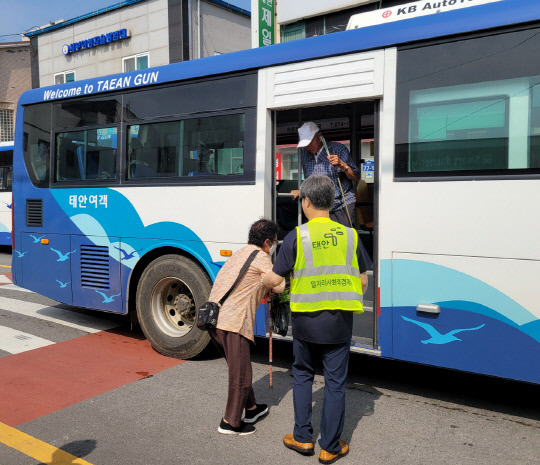 지난 6일 태안읍의 한 버스 정류장에서 노인 승차를 돕고 있는 '정류장 승하차 도우미' 모습.사진=태안군 제공