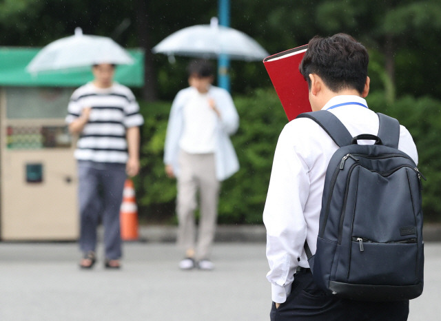 ▲ 소나기가 내린 지난 4일 오후 서울 송파구 aT센터 인근에서  한 시민이 파일북으로 머리를 가리고 있다. [연합뉴스 자료사진]