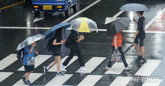 [전주=뉴시스] 김얼 기자 = 경기도 등 수도권을 중심으로 호우주의보가 내려지면서 최대 100㎜의 비가 내릴 전망이다. 사진은 지난 7일 전북 전주시 덕진구 견훤로에서 시민들이 비를 피하며 길을 지나는 모습. 2023.07.07. pmkeul@nwsis.com