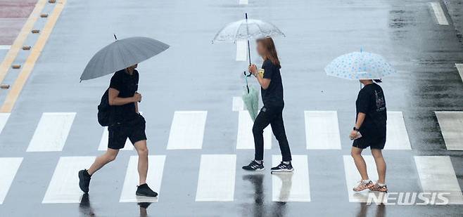 [전주=뉴시스] 김얼 기자 = 9일 경기도와 강원도를 중심으로 발표된 호우주의보가 서울 전역으로 확대되고 있다. 사진은 지난 7일 전북 전주시 덕진구 견훤로에서 시민들이 우산으로 비를 피하며 횡단보도를 건너고 있는 모습. 2023.07.07. pmkeul@nwsis.com