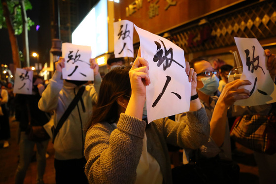 Hong Kong citizens hold up placards in front of the Hong Kong Polytechnic University on Nov. 25, 2019, as they show solidarity with the protesters on campus. [YONHAP]