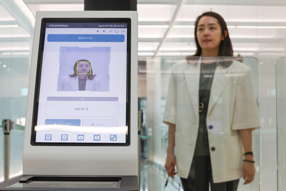 An Incheon International Airport employee demonstrates how to register facial recognition information at the airport on Monday. The Smart Pass system, which enables tourists to undergo departure procedures more easily using only this information, is scheduled to be introduced at the end of the month, while the registration of faces and passport information to use this service has been available on the "ICN SmartPass" mobile application. [YONHAP]