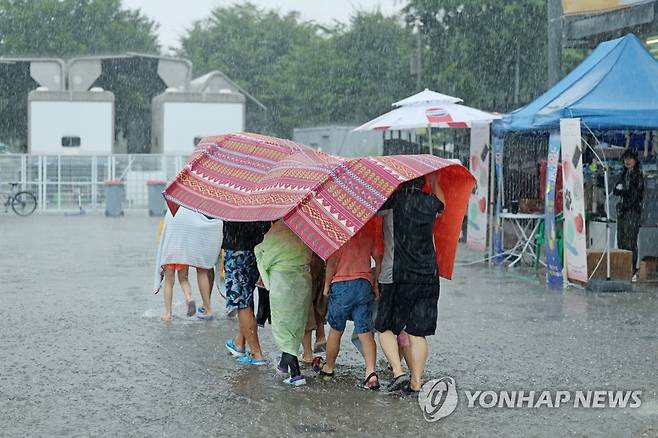 소나기에 돗자리 우산 개시 (서울=연합뉴스) 임화영 기자 = 9일 서울 광진구 한강 뚝섬유원지 일대에서 강한 소나기성 비가 내리고 있다. 2023.7.9 hwayoung7@yna.co.kr