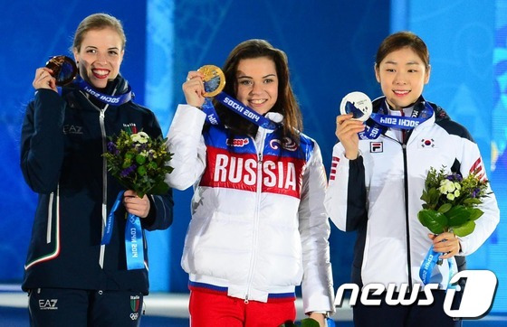 '피겨여왕' 김연아가 22일(한국 시간) 러시아 소치 해안클러스터의 올림픽 파크 내 메달 프라자에서 열린 피겨 여자 싱글 시상식에서 은메달을 목에 걸고 환하게 미소짓고 있다. 1위 아델리나 소트니코바(러시아),2위 김연아(대한민국),3위 카롤리나 코스트너(이탈리아)2014.2.22/뉴스1 DB