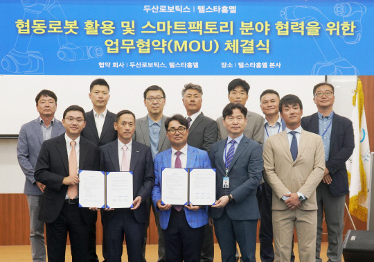 두산로보틱스-텔스타홈멜 MOU 사진 두산로보틱스 류정훈 대표와 박인원 대표(앞줄 왼쪽 두 번째)가 경기 성남시 두산타워에서 열린 텔스타홈멜과의 MOU 체결식에서 관계자들과 기념촬용을 하고 있다. 두산로보틱스 제공