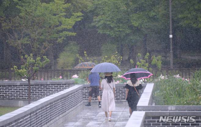 [전주=뉴시스] 김얼 기자 = 장마가 연일 이어지고 있는 4일 전북 전주시 전주덕진공원에서 시민들이 우산을 쓴 채 산책을 즐기고 있다. 2023.07.04. pmkeul@nwsis.com