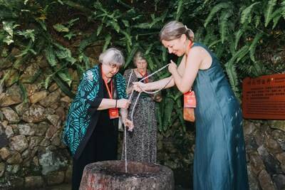 Elyn MacInnis and her daughter use a bucket to draw water from a century-old well in Kuliang. (Photo by Weng Rongfei) (PRNewsfoto/People's Daily)
