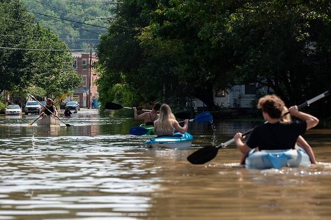 11일(현지시간) 미국 버몬트주 몬트필리어 지역에서 주민들이 카악을 타고 물에 잠긴 시내를 통과하고 있다. AFP연합뉴스