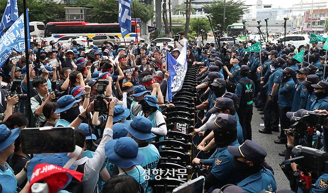 민주노총 금속노조 조합원들이 12일 총파업대회에서 행진한 뒤 신용산역 인근에서 경찰과 대치하고 있다.