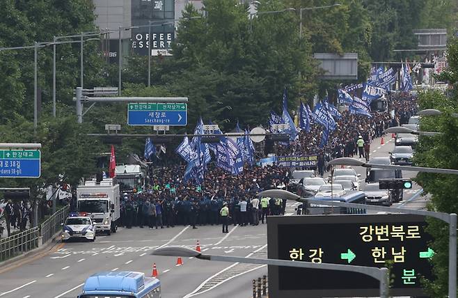 12일 오후 서울 용산구 이촌역 인근에서 전국민주노동조합총연맹이 연 금속노조 총파업대회를 마친 조합원들이 용산 대통령실 방향으로 행진하자 경찰이 신용산역 인근에서 이를 막아서고 있다.