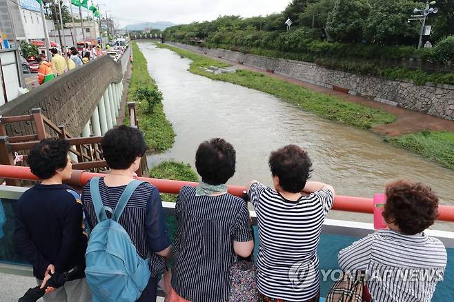 안타까운 심정 (부산=연합뉴스) 박성제 기자 = 부산 사상구 학장천의 물이 불어나면서 60대 시민이 실종됐다는 신고가 접수돼 119 대원들이 12일 오전 수색을 벌이는 가운데 인근 주민들이 학장천을 안타까운 심정으로 바라보고 있다. 2023.7.12 psj19@yna.co.kr