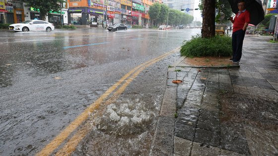 13일 인천시 미추홀구 현대아파트 앞 도로의 한 배수구가 역류하고 있다. 연합뉴스