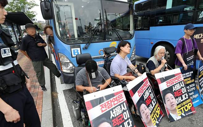 [서울=뉴시스] 김명년 기자 = 13일 오전 서울 종로구 혜화동로터리에서 한 시민이 출근길 버스를 가로막은 박경석 전국장애인차별철폐연대 대표와 회원들에게 항의하고 있다. 2023.07.13.